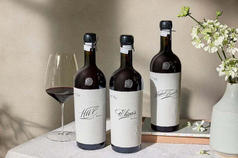 A bottle of Highest Beauty on a table next to a fireplace.